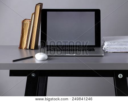 Workspace With Computer And Stack Of Papres In Office .