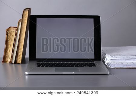 Workspace With Computer And Stack Of Papres In Office .
