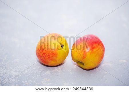 Two Ripe Fresh Nectarines On A Gray Background, Close-up