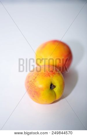 Two Ripe Nectarines On A White Background. Food Photo, Fruit