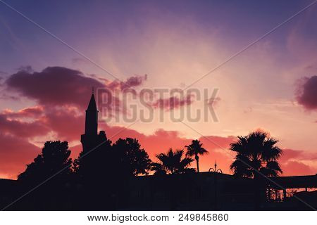 Silhouette Of Buyuk Cami Mosque And Palm Trees Against Colorful Sky At Sunset. Larnaca, Cyprus