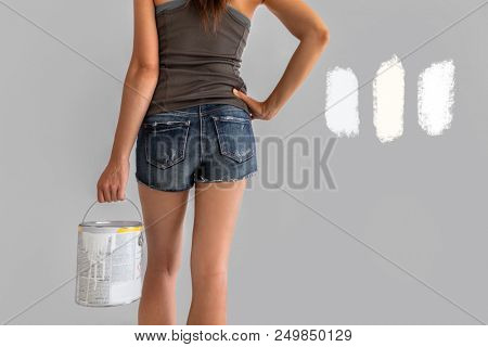 Home renovation woman confused between different shades of white paint choosing tones of warm and cold whites in eggshell sheen. Girl painting walls during house remodel.