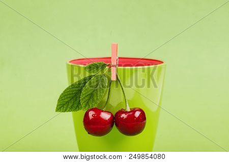 Fresh Cherries With Green Glass On Green Background