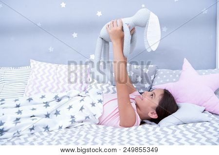 Best Friends. Girl Child Lay On Bed With Grey Bunny Toy In Her Bedroom. Kid Prepare To Go To Bed. Wi