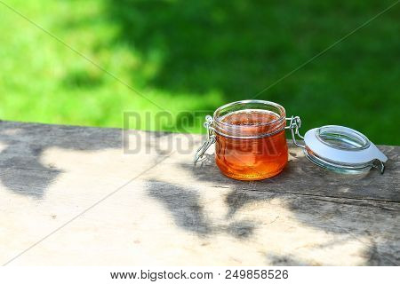 Jar Of Fresh Honey In A Glass Jar On An Old Table On A Apiary. Outside. Beekeeping Concept. Top View