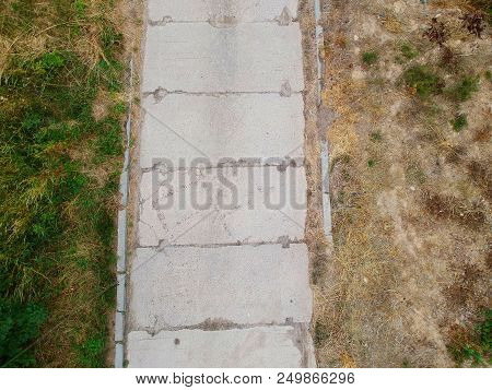 Old Concrete Slab Road In Dry And Grassy Environment, Aerial View.