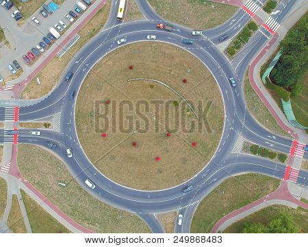 Roundabout intersection in five directions with island, aerial view.