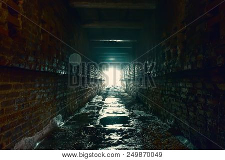 Light And Exit In End Of Dark Long Brick Abandoned Industrial Tunnel Or Corridor Or Sewer Channel, W