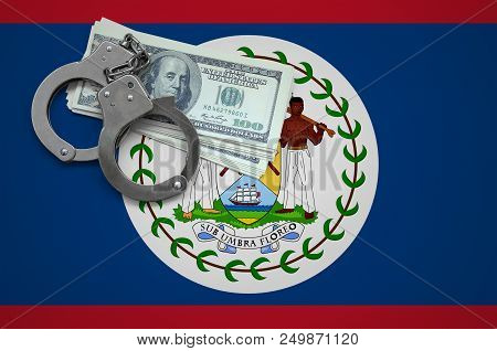 Belize Flag  With Handcuffs And A Bundle Of Dollars. The Concept Of Breaking The Law And Thieves Cri