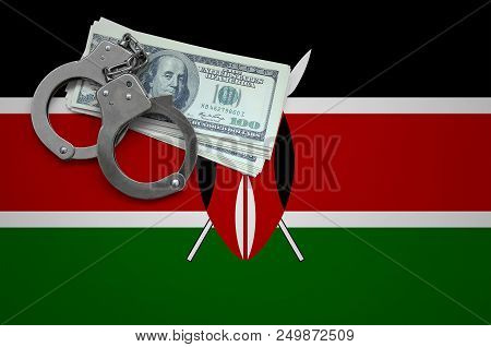 Kenya Flag  With Handcuffs And A Bundle Of Dollars. The Concept Of Breaking The Law And Thieves Crim
