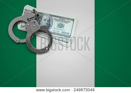 Nigeria Flag  With Handcuffs And A Bundle Of Dollars. The Concept Of Breaking The Law And Thieves Cr