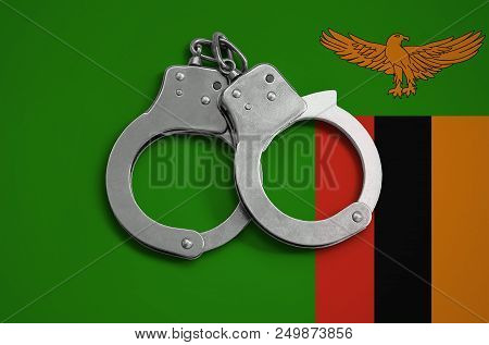 Zambia Flag  And Police Handcuffs. The Concept Of Observance Of The Law In The Country And Protectio