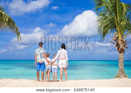 Family Of Four On Beach Vacation On Caribbean Island