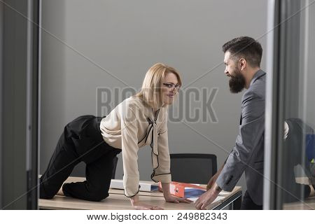 Office Romance Concept. Sexy Secretary Seduce Boss In Office. Businesswoman On Desktop Look At Beard
