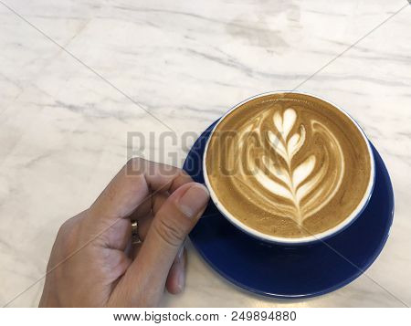Asian Hand Holding Cup Of Coffee With Latte Art