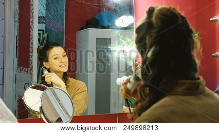 Young Beautiful Girl Curls Her Hair On A Curling Robe In The Dressing Room, The Artist Prepares For 