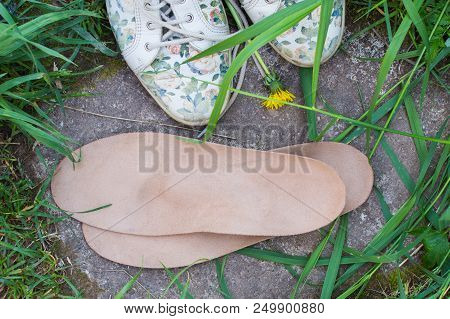 Leather Orthopedic Insoles With Running Shoes On The Grass. Healthy Relax On Nature. Outdoors.
