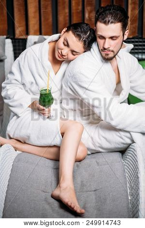 Close Up Portrait Of Loving Couple Sitting In The Resort In The White Bathrobes. Secure Foothold Con