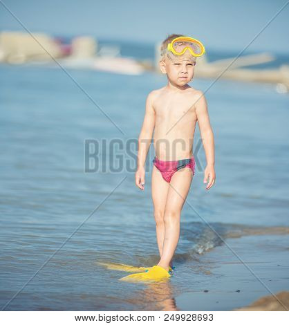 Little Boy With Snorkel By The Sea. Cute Little Kid Wearing Mask And Flippers For Diving At Sand Tro