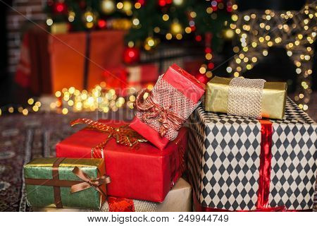 Christmas Gift Box. Christmas Presents In Red And Brown Boxes On Christmas Tree Background In Loft I