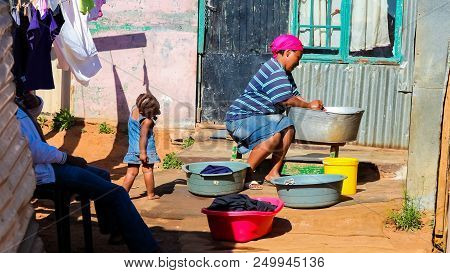 Johannesburg, South Africa, September 11, 2011, African Mother And Child Washing Clothes In Low-inco