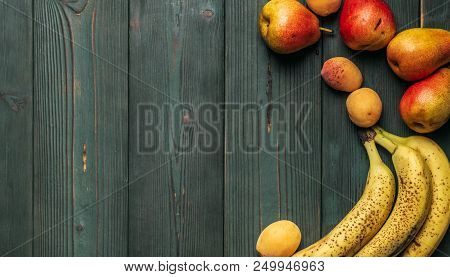 Detox: A Scattering Of Fresh Ripe Bananas, Pears And Apricots On A Wooden Green Table. Frame With Co