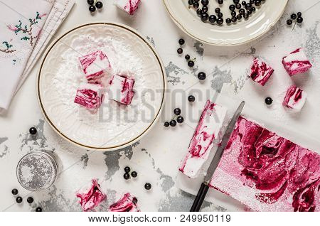 Blackcurrant Swirl Marshmallow In A Plate With Icing Sugar
