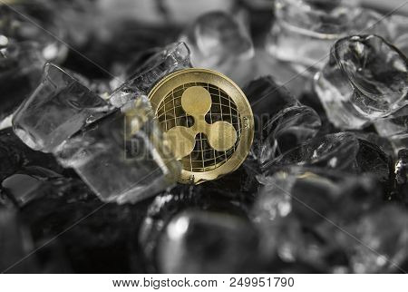 Gold Ripple Coin On Ice Background. The Concept Of The Exchange In Winter. Freeze. Blockchain Mining
