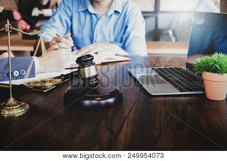 Business Meeting And Lawyers. Justice Scales, Justice Hammer And Laptop Computer With Discussing Lit