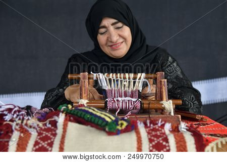 Moscow, Russia - July 14, 2018: A Senior Arabian Woman Makes A Traditional Sadu Weaving. Focus On Th
