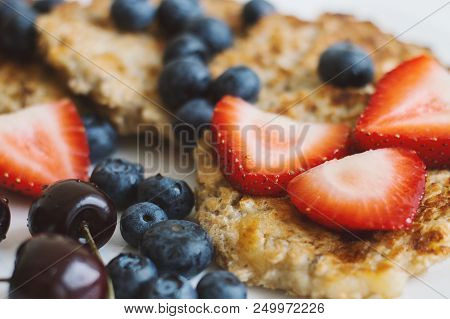 Brown Whole Grain Pancakes Served With Fresh Strawberry Slices, Bluberry And Cherry. Healthy And Bal