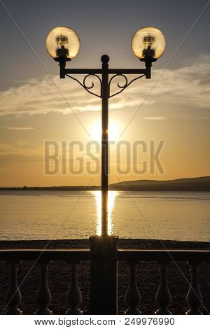 Quay Of Gelendzhik. The Setting Sun, Silhouette, Lights, Solar Path Center. Krasnodar Krai