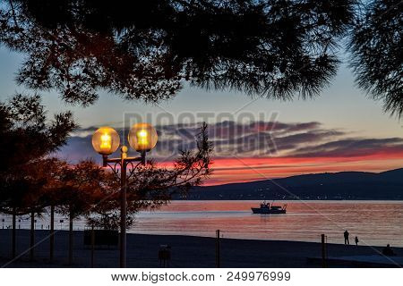 Quay Of Gelendzhik. The Setting Sun, Silhouette, Lights, Solar Path Center. Krasnodar Krai
