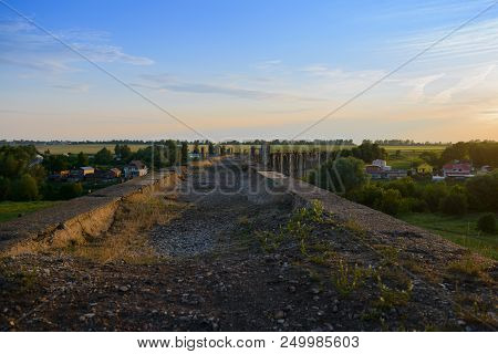 Old Concrete Arch Bridge Near The Village At Sunset Of The Day