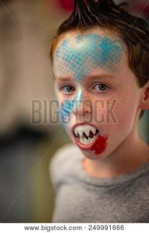 View Of Boy With Face Painted Like A Shark