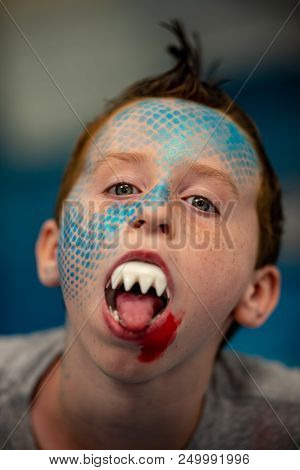 View Of Boy With Face Painted Like A Shark
