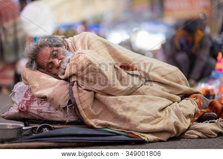 PURI, INDIA, JANUARY 13, 2019 : A homeless man is sleeping in the street of the Puri outdoor market.