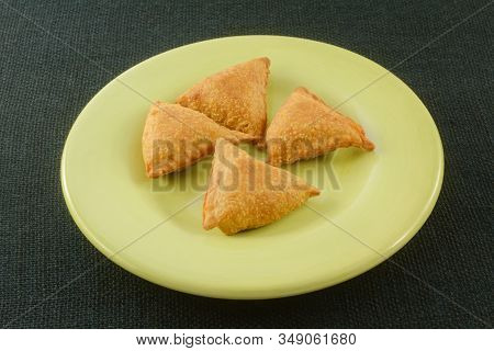 Warm Cooked Samosa Pastry Snacks Or Appetizers On Light Green Plate On Dark Green Background