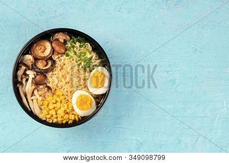 Ramen. Soba Noodles With Eggs, Shiitake And Enoki Mushrooms, And Vegetables, Shot From Above On A Bl