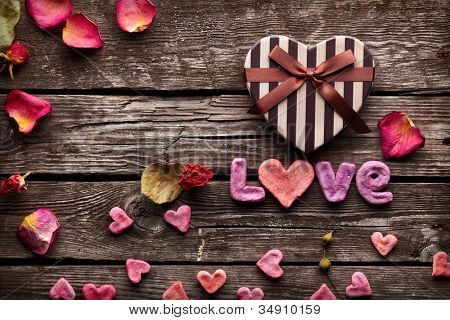 คำรักกับหัวใจรูปกล่องของขวัญวันวาเลนไทน์บนแผ่นไม้เก่าโบราณ หลังวันหยุดหวาน