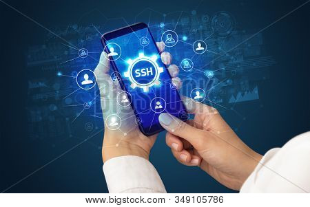 Female hand holding smartphone with SSH abbreviation, modern technology concept