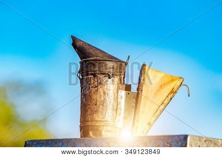 Old Bee Smoker. Beekeeping Tool. Beekeeper Inspecting Bee Hive