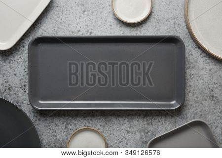 Crockery, Clayware, Empty Grey Modern Utensils And Different Stuff On Grey Tabletop. View From Above