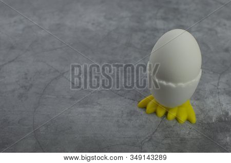 White Egg In An Egg Stand With Chicken Legs On A Gray Concrete Background Easter Copyspace