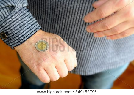 The Spanish Coin Lies On A Male Hand. The Game 