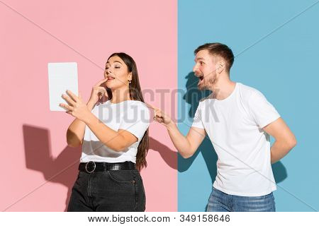 No Selfie. He Tries To Pay Her Attention. Young, Happy Man And Woman In Casual Clothes On Pink, Blue
