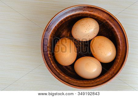 Four In Shell Eggs Are Floating In A Ceramic Bowl Of Water. Cool Boiled Eggs For Further Slicing. Co