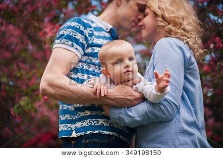 Happy Family Mother, Father, Little Son For A Walk In The Summer Park.happy Young Family Spending Ti