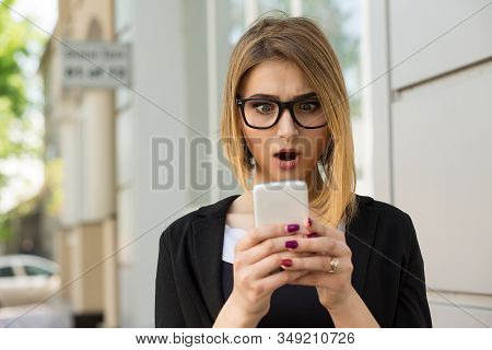 Woman Shocked With Sms Message On Phone. Closeup Woman Girl Looking At Cellphone Stunned Surprised F
