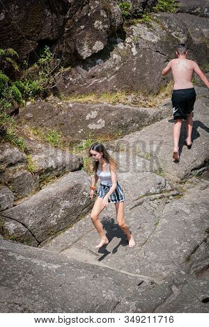 Tauranga New Zealand - January 22 2019; Young Male Running Away And Female Running Toward On Rocks H